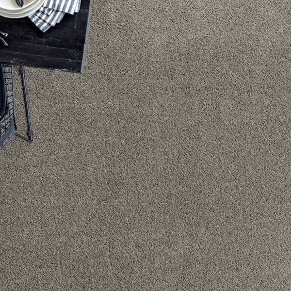 Carpet flooring with black dining table and chair.