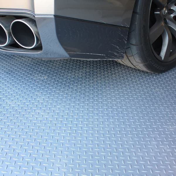 Car tire and body over Stainless Steel diamond-pattern vinyl garage flooring.
