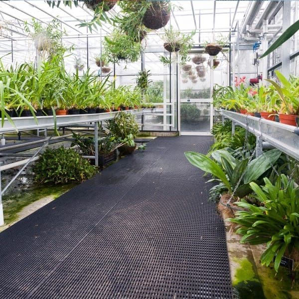 Greenhouse walkway with black Plastex Vynagrip heavy duty drainage mats