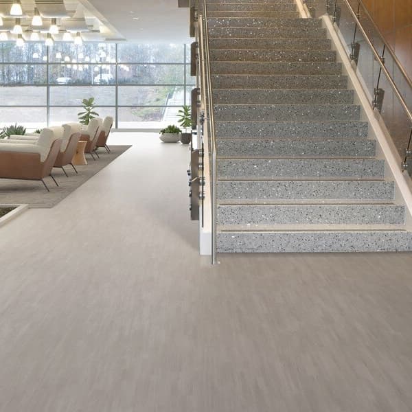 Mannington Realities II 6' Vinyl Sheet in light gray stone pattern — modern office lobby with staircase and seating area