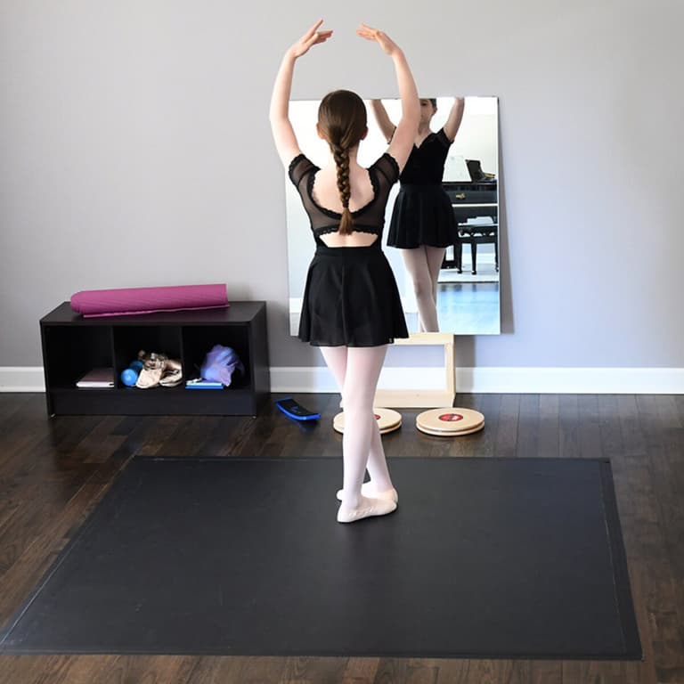 Rosco Marley Mat™ black dance flooring in a studio with a dancer practicing ballet