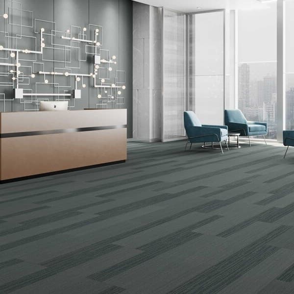 Modern office lobby with Pentz Cliffhanger Carpet Planks in Sierra Periona, featuring dark gray and charcoal geometric