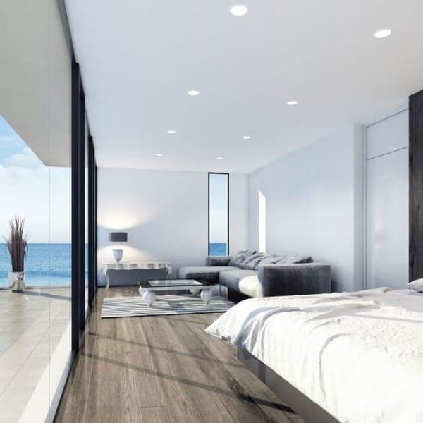 Engineered hardwood in bedroom with gray couch overlooking the ocean.