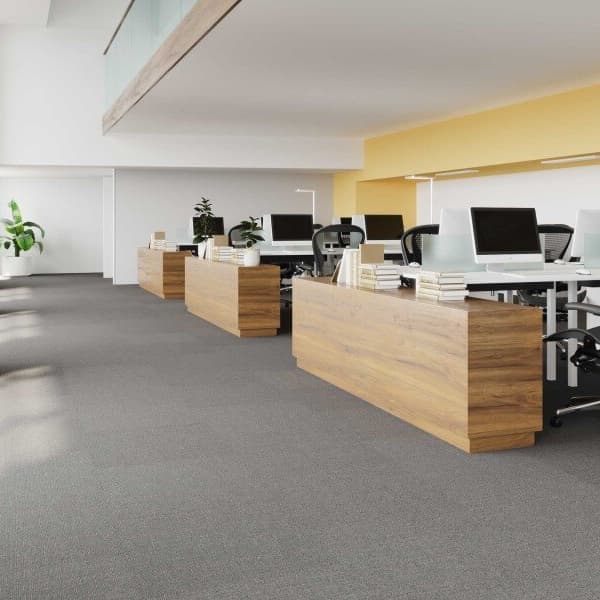Open office space with Pentz Oasis Carpet Tiles in Gobi, featuring neutral gray carpet under wooden desks and ergonomic