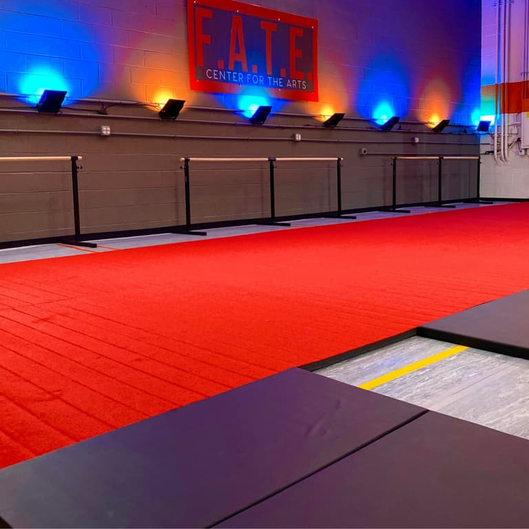 Gymnasium with red Cheer Mats and purple folding mats, ballet barres along wall