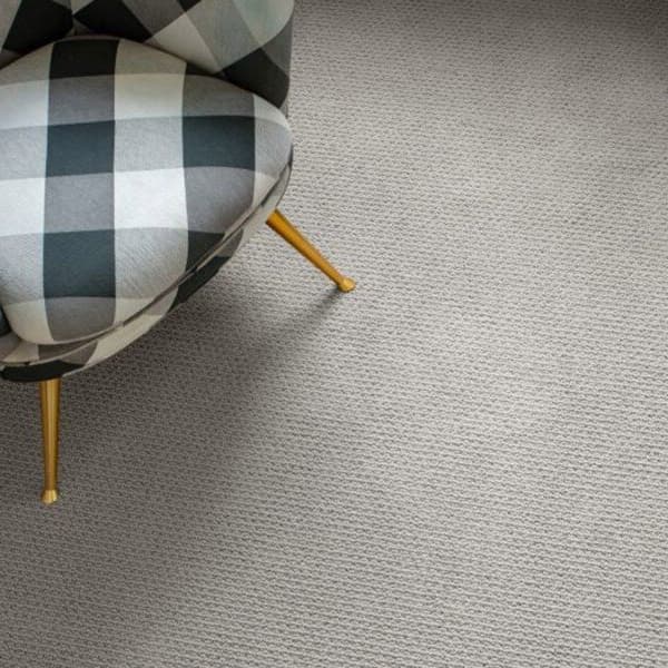 Carpet flooring in room with checkered chair.