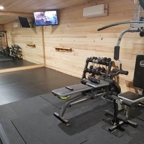 Black rubber gym mats in at-home gym.