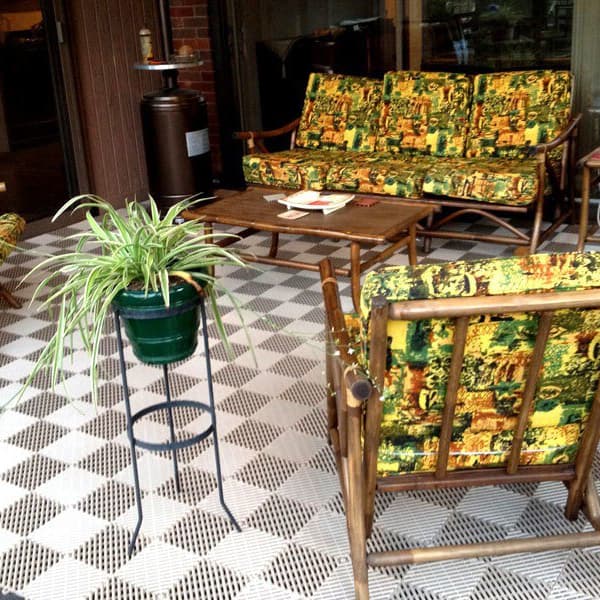Vented grip-loc drainage tiles in a checkered pattern with white and brown tiles, and colorful chairs and wooden table.