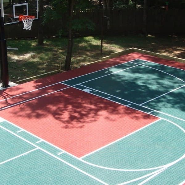Outdoor basketball court with Premium Outdoor Sports Tiles in green and red, white lines marking play areas