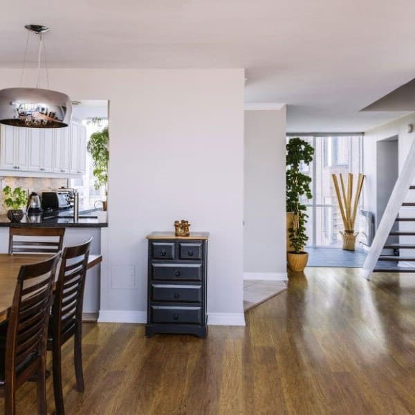 Open concept dining and kitchen area with Italia Engineered Hardwood flooring, visible under wooden table and extending