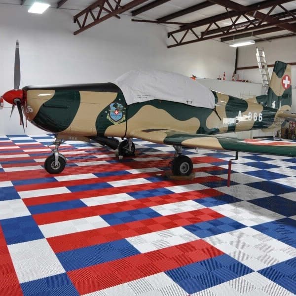 Garage with airplane on Swisstrax Ribtrax Pro Tiles in red, white, and blue checkerboard pattern