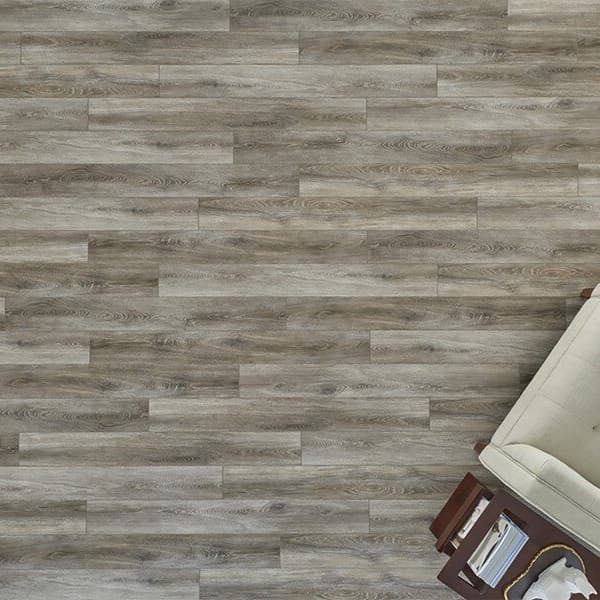 Dockside Driftwood vinyl plank flooring in living room with beige sofa and side table