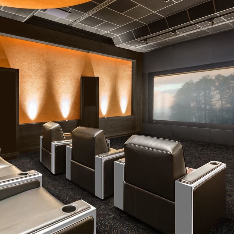 Home theater with dark patterned carpet under reclining seats and large screen