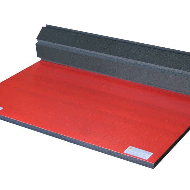 Red and black polyethylene foam wrestling mat, partially rolled