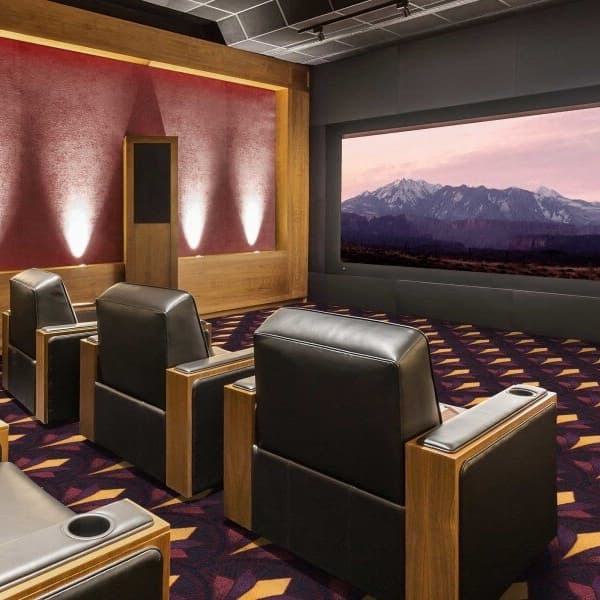 Joy Carpets Bryant Park Carpet, burgundy and gold geometric pattern — home theater room with recliners and large screen