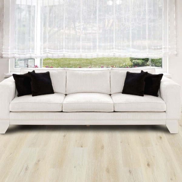 Living room with white sofa and black pillows, featuring light oak vinyl plank flooring