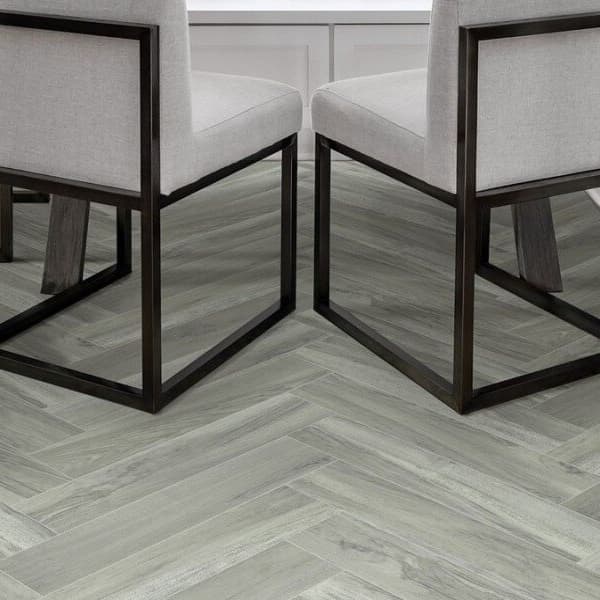 Shaw Serendipity 12' wide vinyl sheet in Andromeda — dining room floor with herringbone pattern, light gray wood grain