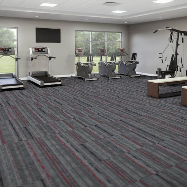 EF Contract Contact Sport Carpet Tiles, Slam Dunk — fitness room with treadmills and exercise bikes on gray carpet with red