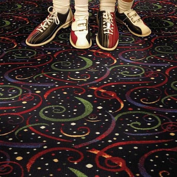 Shaw Joker's Wild Carpet, What Luck — dark carpet with red, green, blue, and yellow swirls and white dots