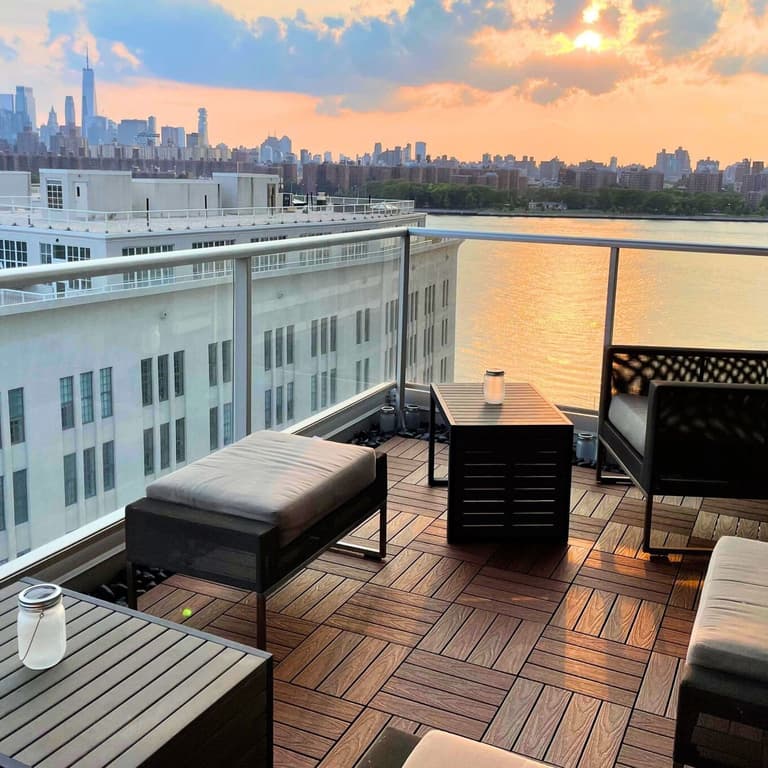 Rooftop deck with NewTechWood UltraShield 12" x 12" composite deck tiles, featuring outdoor furniture and city skyline view