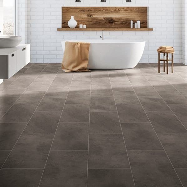 Pietra 12" rigid core vinyl planks in Granite Gray — modern bathroom with white subway tile walls and freestanding tub