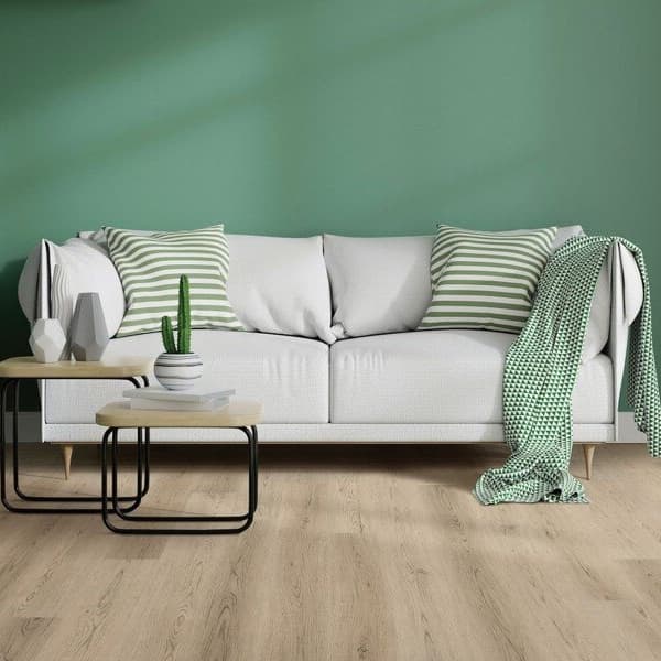 Living room with COREtec Plus 7" waterproof vinyl planks in Alabaster Oak, light wood grain flooring under a white sofa and