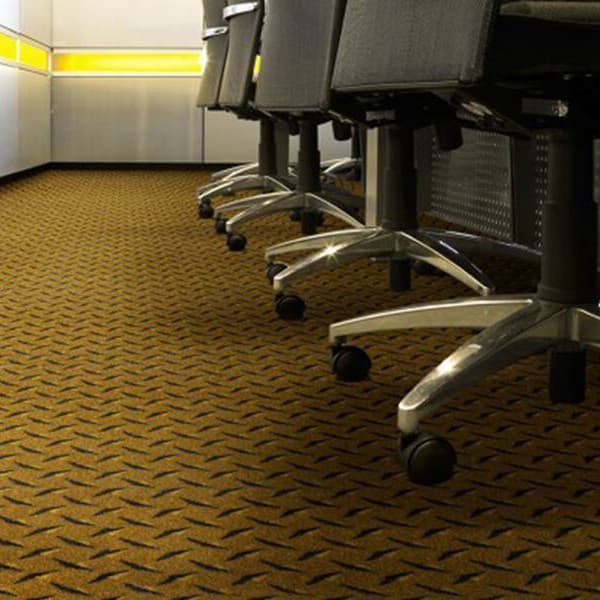 Joy Carpets Diamond Plate Carpet in Gold — office space with patterned nylon carpet under rolling chairs and cubicle walls
