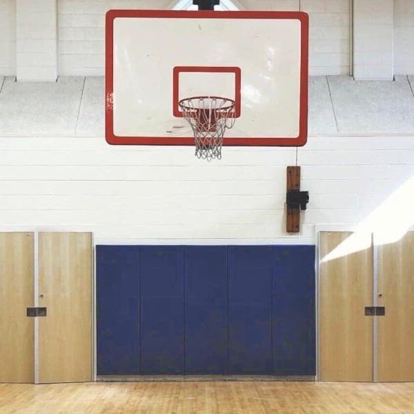 Blue wall pads in the gymnasium behind the basketball hoop.