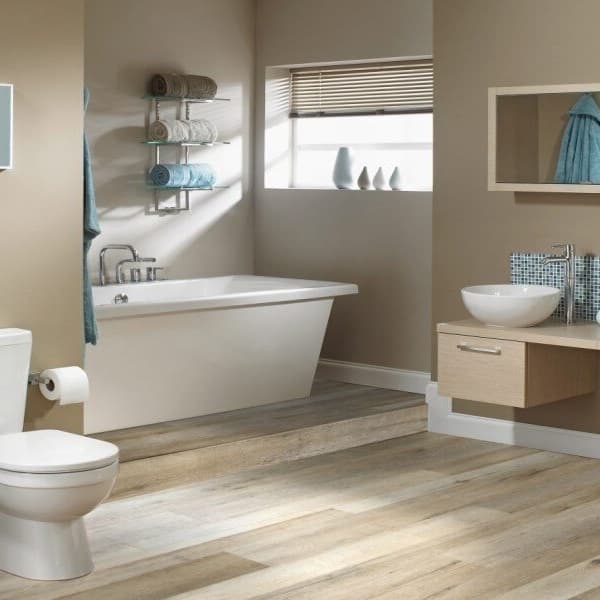 Bathroom with Johnson Sicily rigid core vinyl planks in Santa Croce light wood grain pattern under toilet, bathtub, and