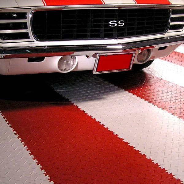 Diamond plate garage floor tiles in red and white with a classic white car parked on the tiles.