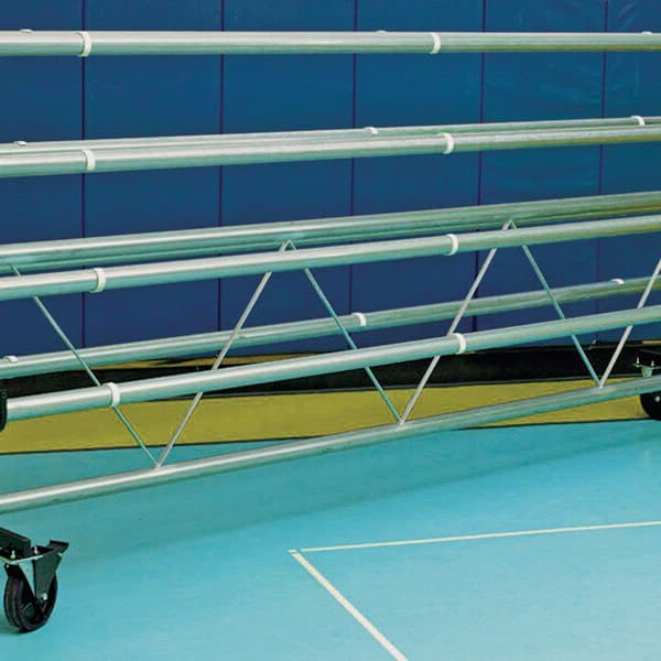 Mobile storage rack for gym floor covers, galvanized steel frame with multiple rollers and casters, on blue gym flooring