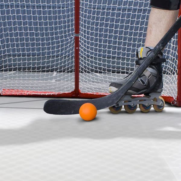 HotShot Hockey Floor Tiles, Glacier — roller hockey net, stick, puck, and skates on light gray tiled surface