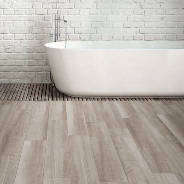 Shaw Paladin Plus 7" rigid core vinyl planks in Driftwood — bathroom with freestanding tub and white brick walls