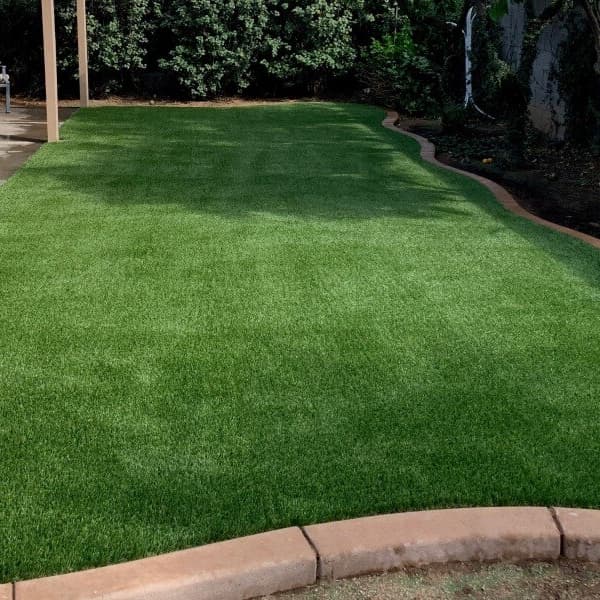 Artificial turf rolls in backyard.
