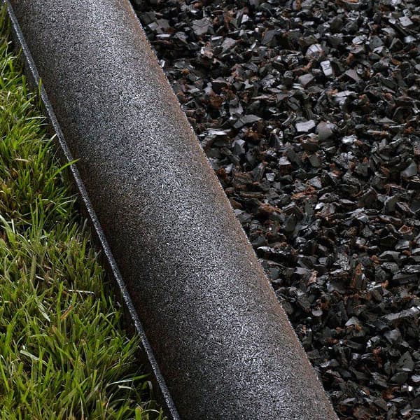 Rubber Timbers - Classic Black recycled rubber roll on grass and loose rubber mulch