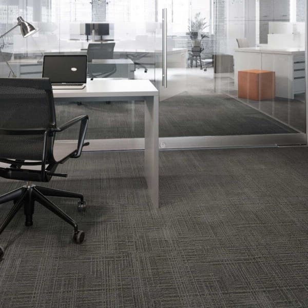 Modern office space with Mannington Relay Carpet Tiles in Haptics pattern, dark gray textured carpet covering the floor under