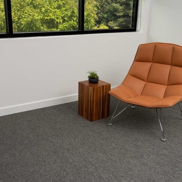 Pentz Dynamic Carpet Tiles, Modern — gray carpet tile flooring in a modern office lounge with orange chair and wooden side