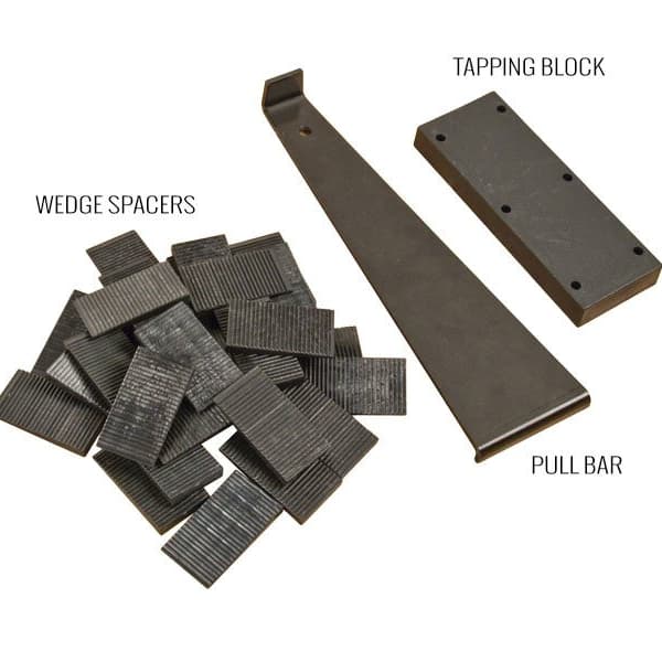 Flooring installation kit with wedge spacers, pull bar, and tapping block on white background