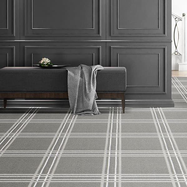 Joy Carpets Broadfield Carpet, Smoke — gray plaid carpet in a room with a bench and paneled walls