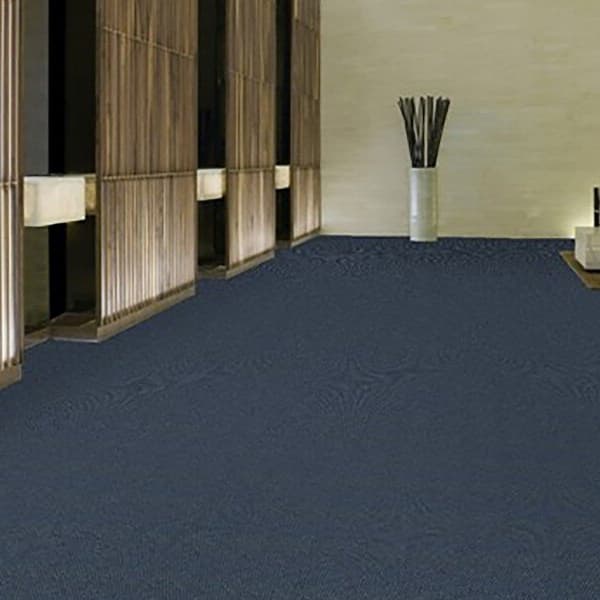 Shaw Commons II Outdoor Carpet in Indigo — dark blue textured carpet covering a modern hallway with wooden slat walls and
