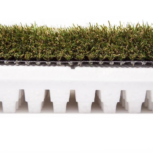 Shaw Play Pad 8 artificial grass — green polypropylene turf with white foam backing, close-up side profile view
