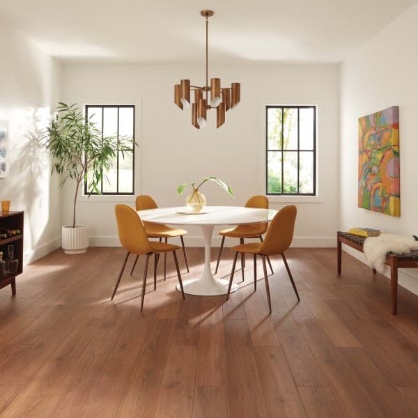 Dining room with COREtec XL Premium Plus HD 7" waterproof planks in Aver Walnut, featuring a white table and orange chairs