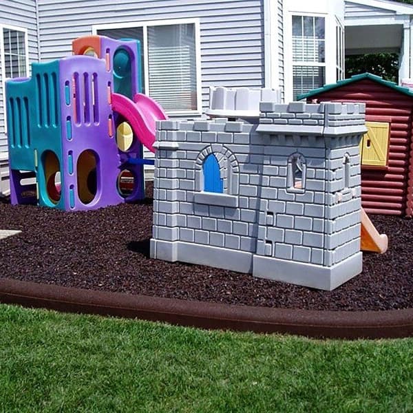 Rubberific Playground Border in Redwood — curved recycled rubber border surrounding a playground with mulch and play