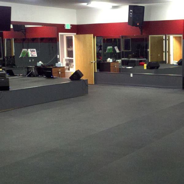 Eco-Flec rubber rolls in a multi-use gym or studio with stage and sound equipment.