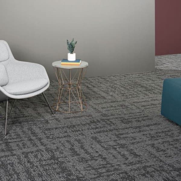 EF Contract Terrain Park Carpet Tiles, Grayness — modern lounge area with gray textured carpet tiles under a white chair and