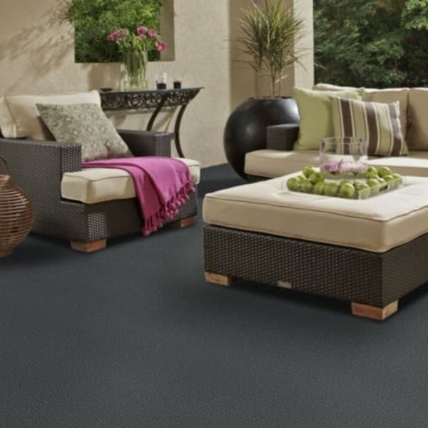 Shaw Backdrop I Outdoor Carpet in Iron Blue — patio with wicker furniture and cushioned seating on dark gray textured carpet