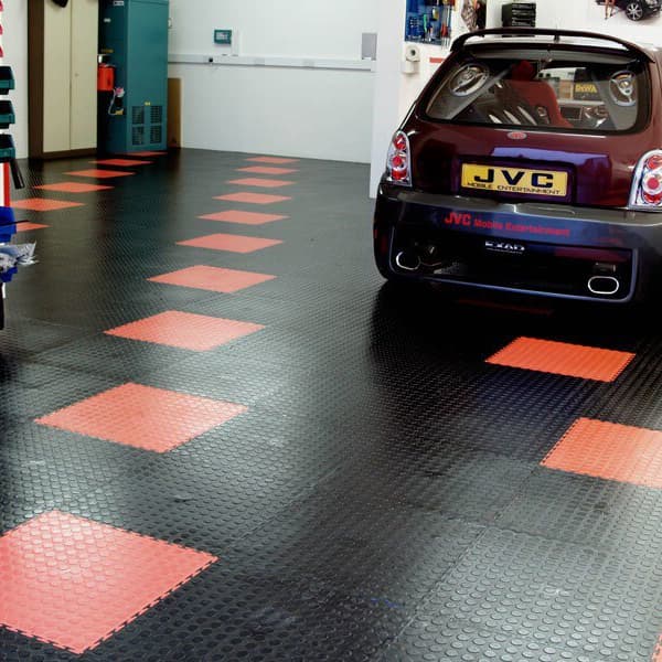 Maroon car in garage with black and red coin flex interlocking tiles.