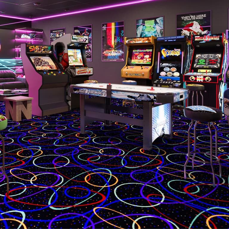 Joy Carpets Neon Lights Carpet — black carpet with colorful looping patterns, installed in a retro arcade room