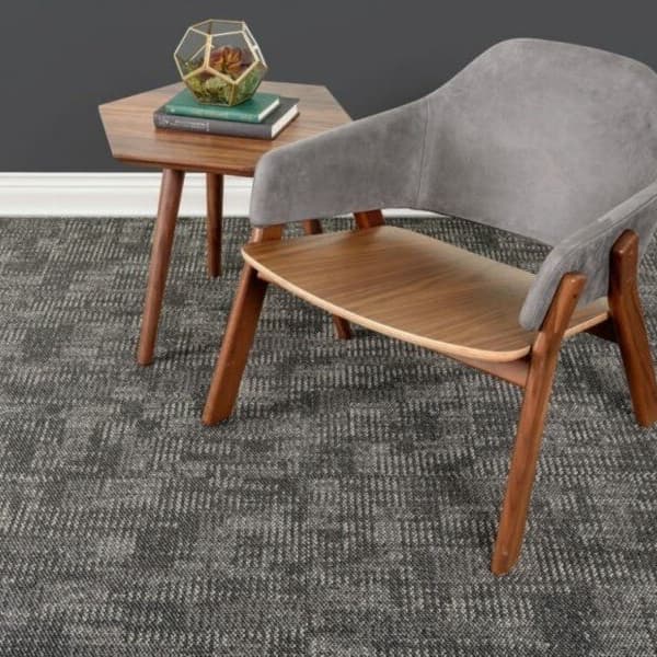 J&J Flooring Intrinsic Carpet Tile, Essential — modern office space with gray textured carpet tile under a wooden chair and